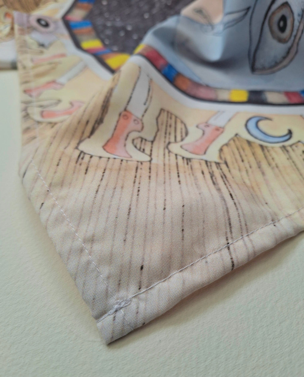 Close-up of stitching on a bandana with printed dark tarot design 