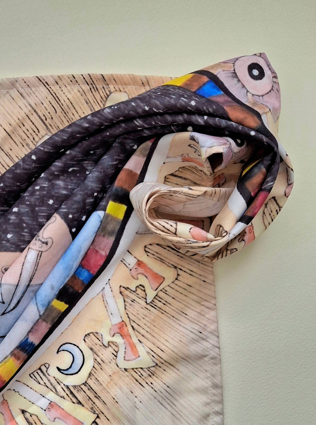 Tarot cloth with dark surrealist print of colourful stripes and blue moons