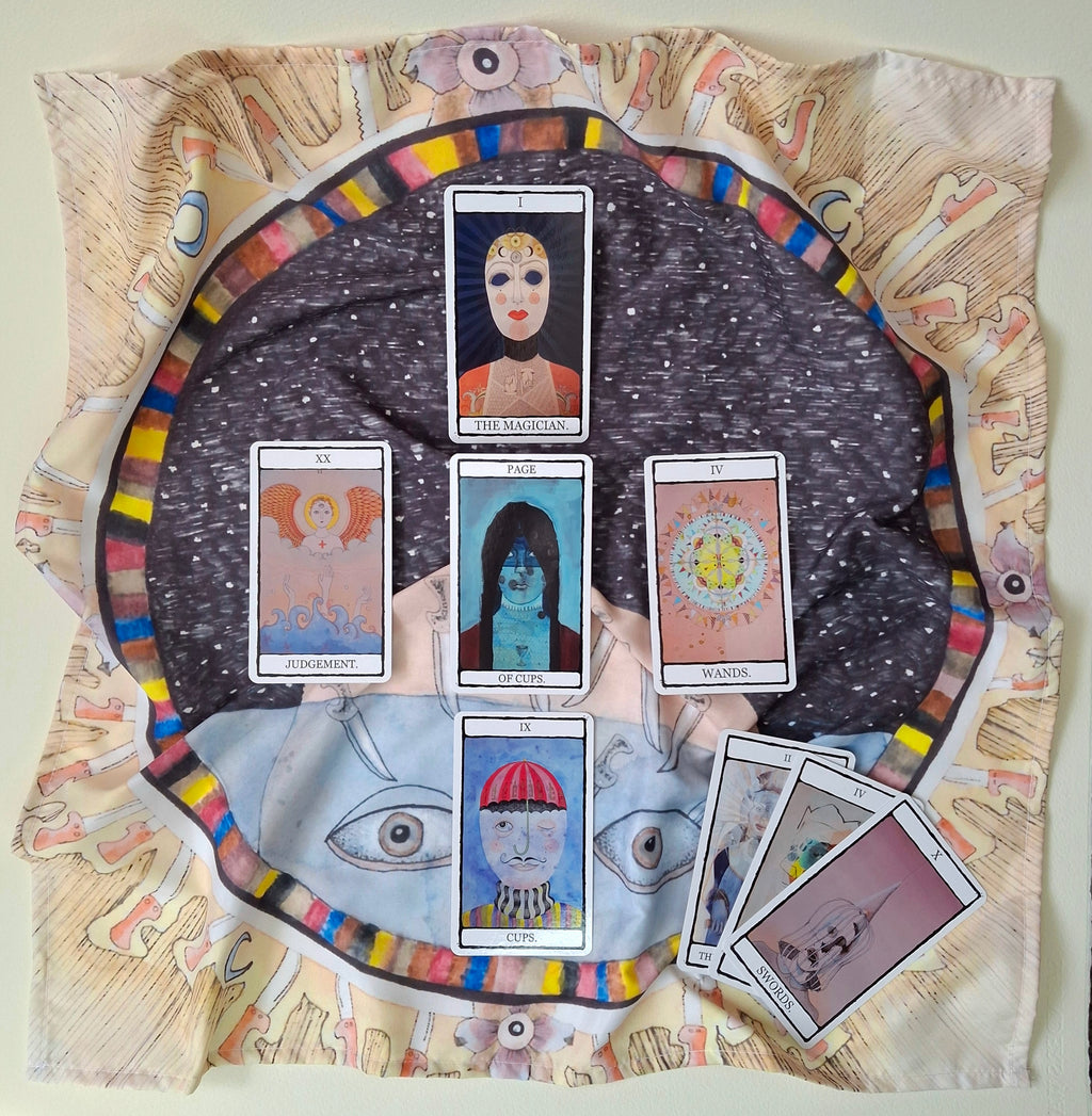Tarot cards on a dark surrealist cloth featuring original illustration of the 9 of Swords