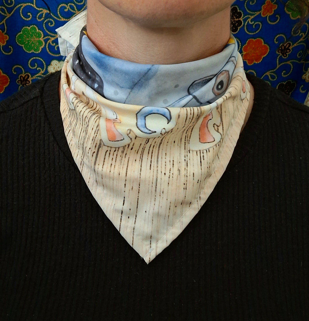 Person wearing a printed scarf with pictures of moons and surreal eyes