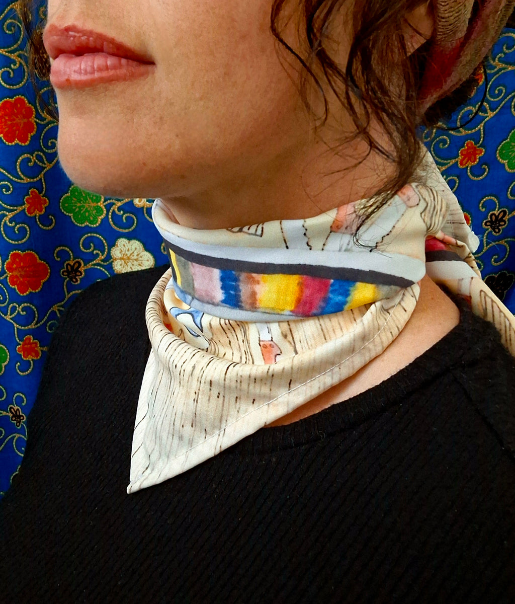 Person wearing a colourful printed scarf in front of a bright background
