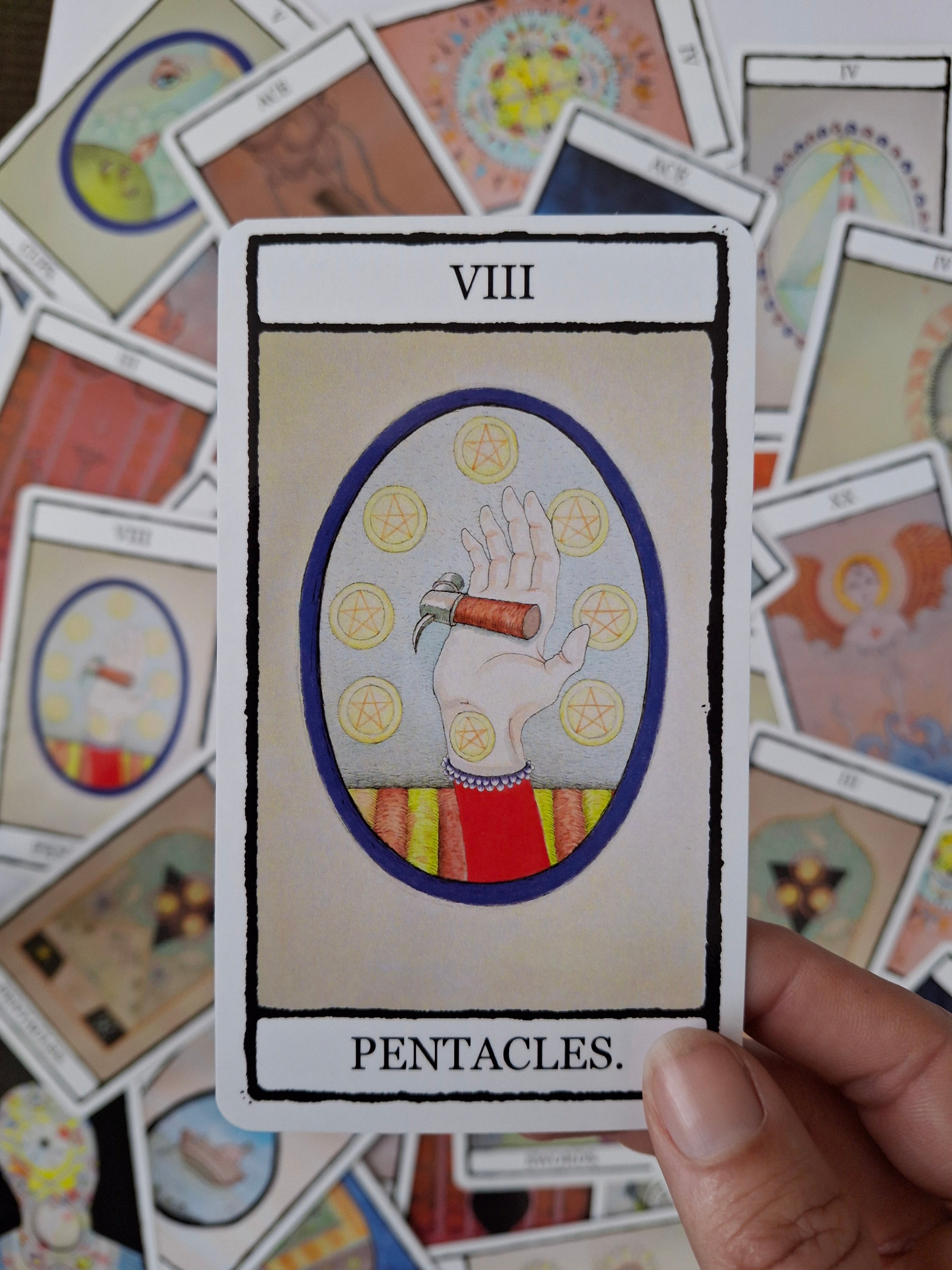 8 of Pentacles tarot card featuring a colourful hand illustrated hand with a cute hammer and 8 pentacles