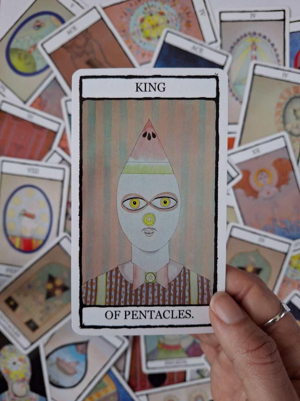 Tarot card with King of Pentacles illustrations featuring a cute character with a watermelon and stripes