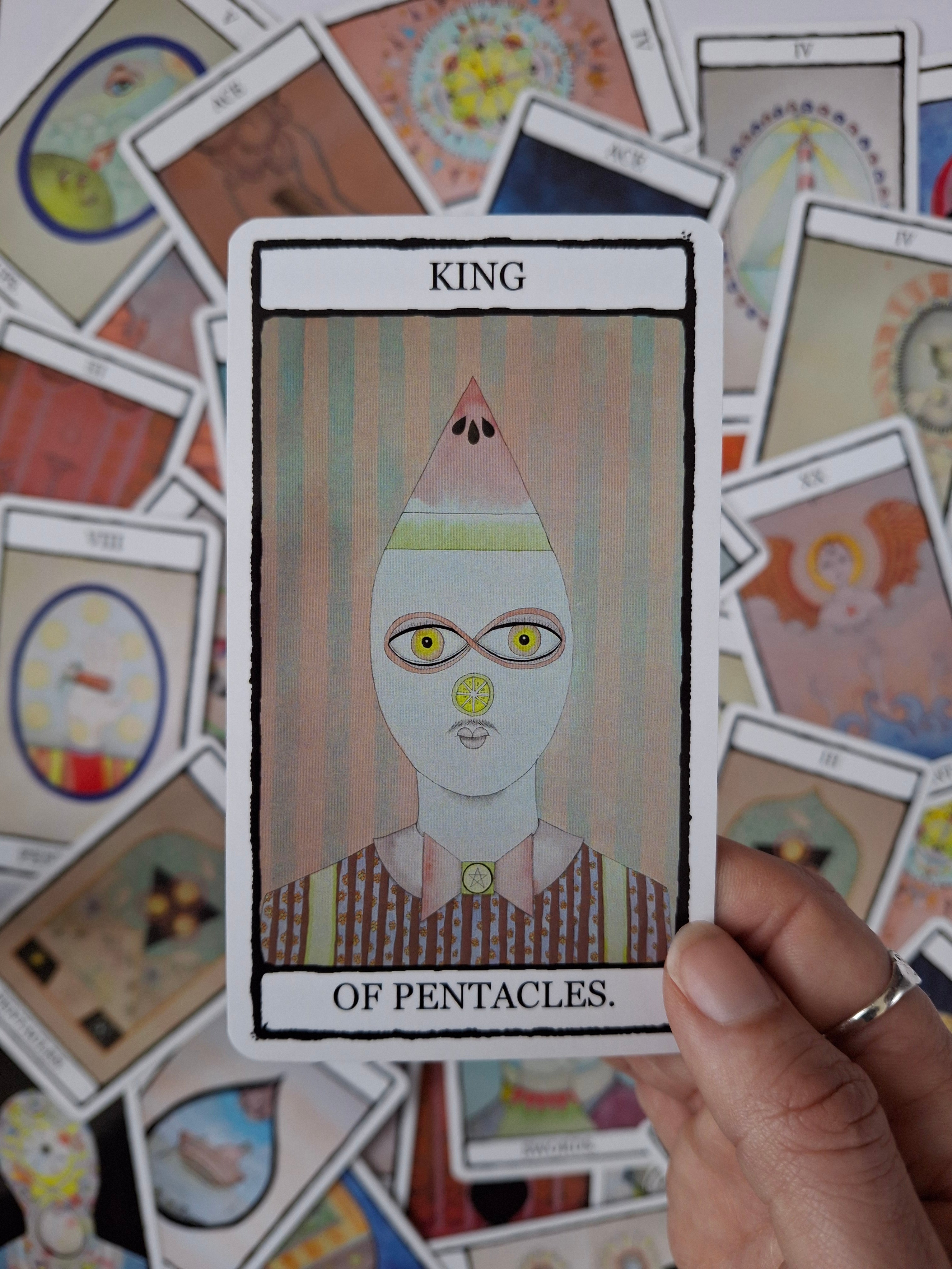 Tarot card with King of Pentacles illustrations featuring a cute character with a watermelon and stripes